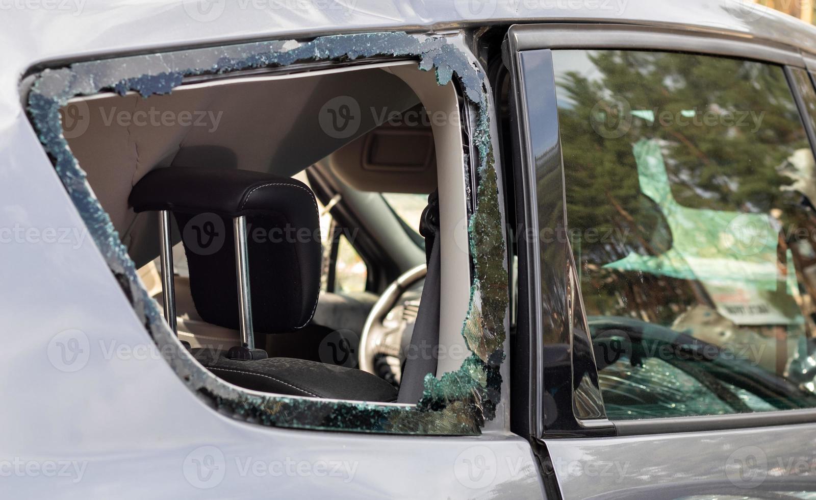 Criminal incident. Breaking into a car parked on the street. Broken side glass and the passenger compartment behind it. A crime committed by a thief, stealing things. Car after an accident. photo