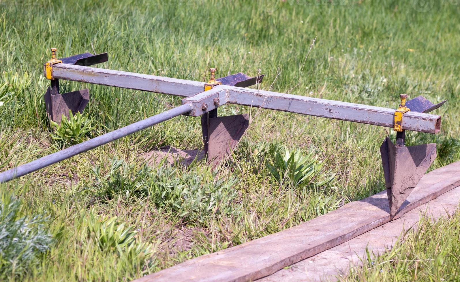 Agricultural manual metal plow on the field. Plowing the land before sowing. Close-up. Inventory for plowing potatoes in the countryside. A plow is a tool for plowing dense soil, raising virgin soil. photo