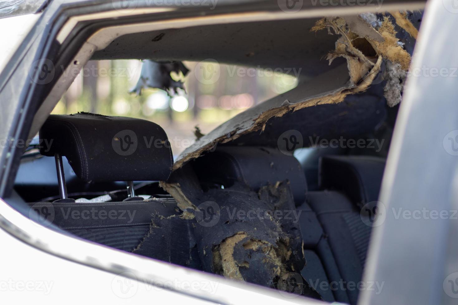 A car after an accident with a broken rear and side glass, view from the rear window. Broken window in a vehicle. The wreckage of the saloon, a detailed close-up view of the damaged car. photo