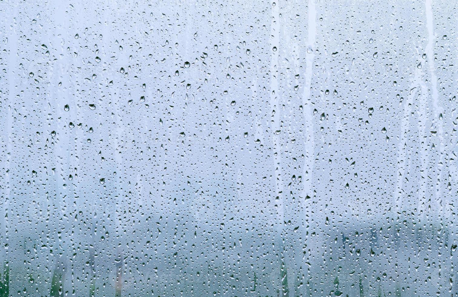 Rain drop on glass window at day time in monsoon season with blurred background. photo