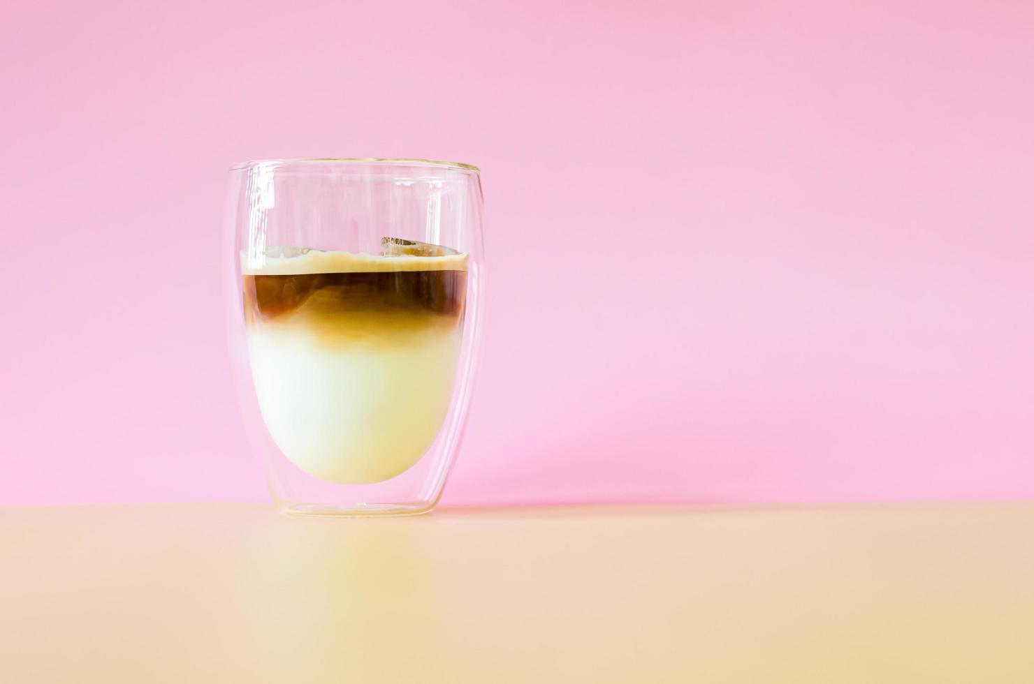 un vaso que se cubre con un poco de vapor de café mezclando leche foto