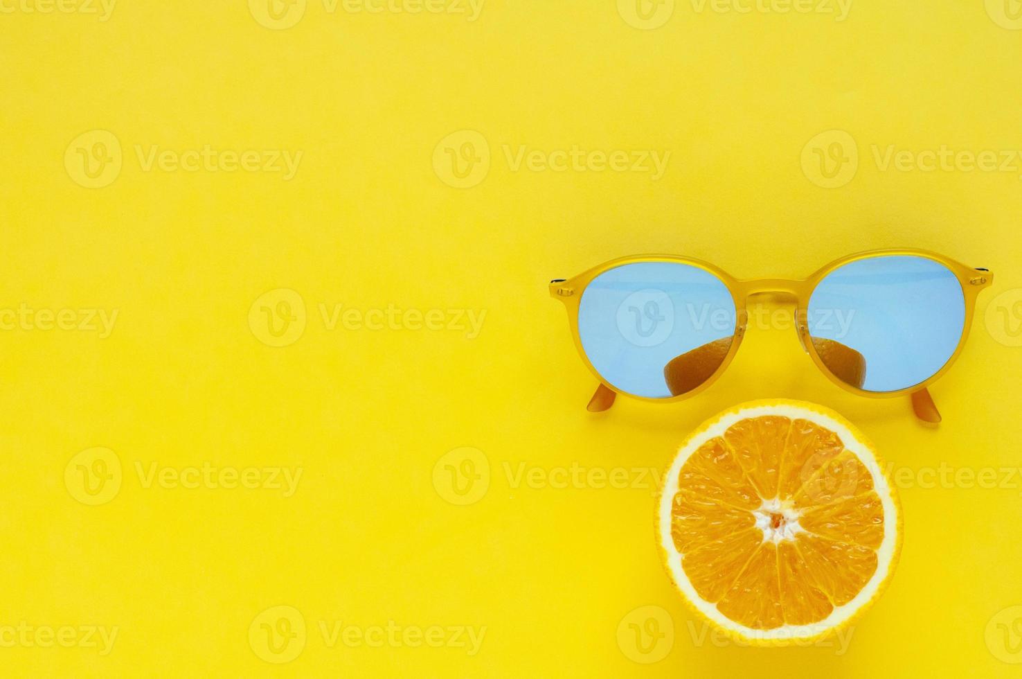 Slice orange fruit and yellow sunglasses. photo