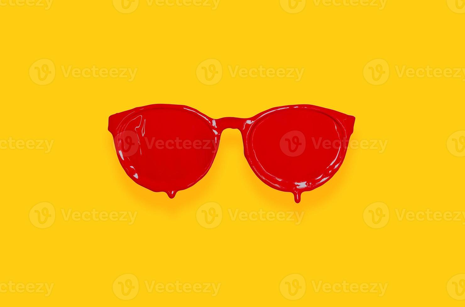 Red poster color painted on sunglasses with yellow background. photo