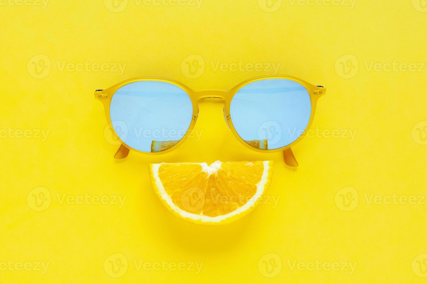 Slice orange fruit sets as smile mouth and yellow sunglasses. photo