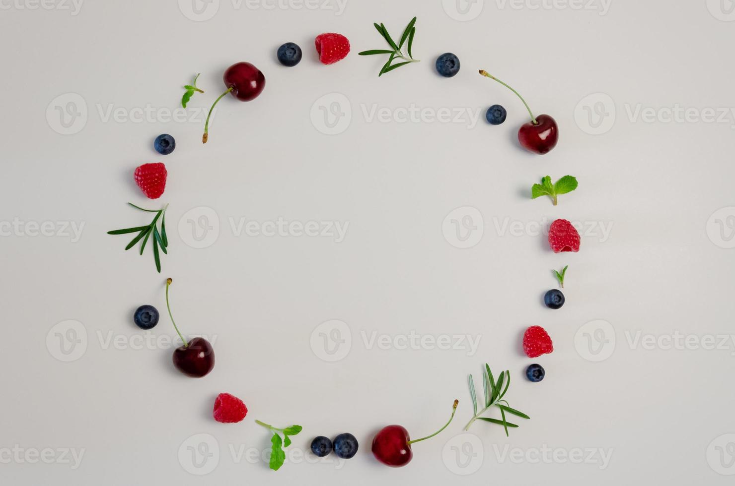 Fresh cherry, blueberry, raspberry, mint and rosemary leaf on top view with white background for healthy food concept. photo