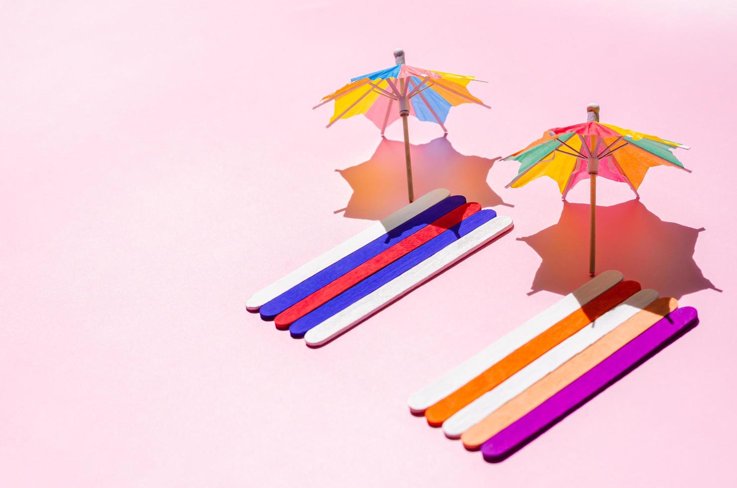 Colorful beach towels with sun umbrellas on pink sand beach. photo