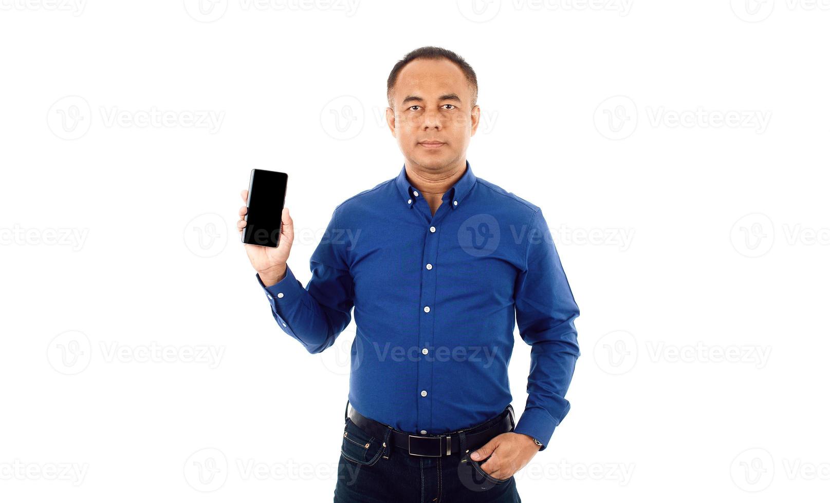 un hombre asiático mayor seguro de sí mismo de mediana edad con una camisa informal azul de negocios que sostiene el teléfono inteligente. aislar sobre fondo blanco foto