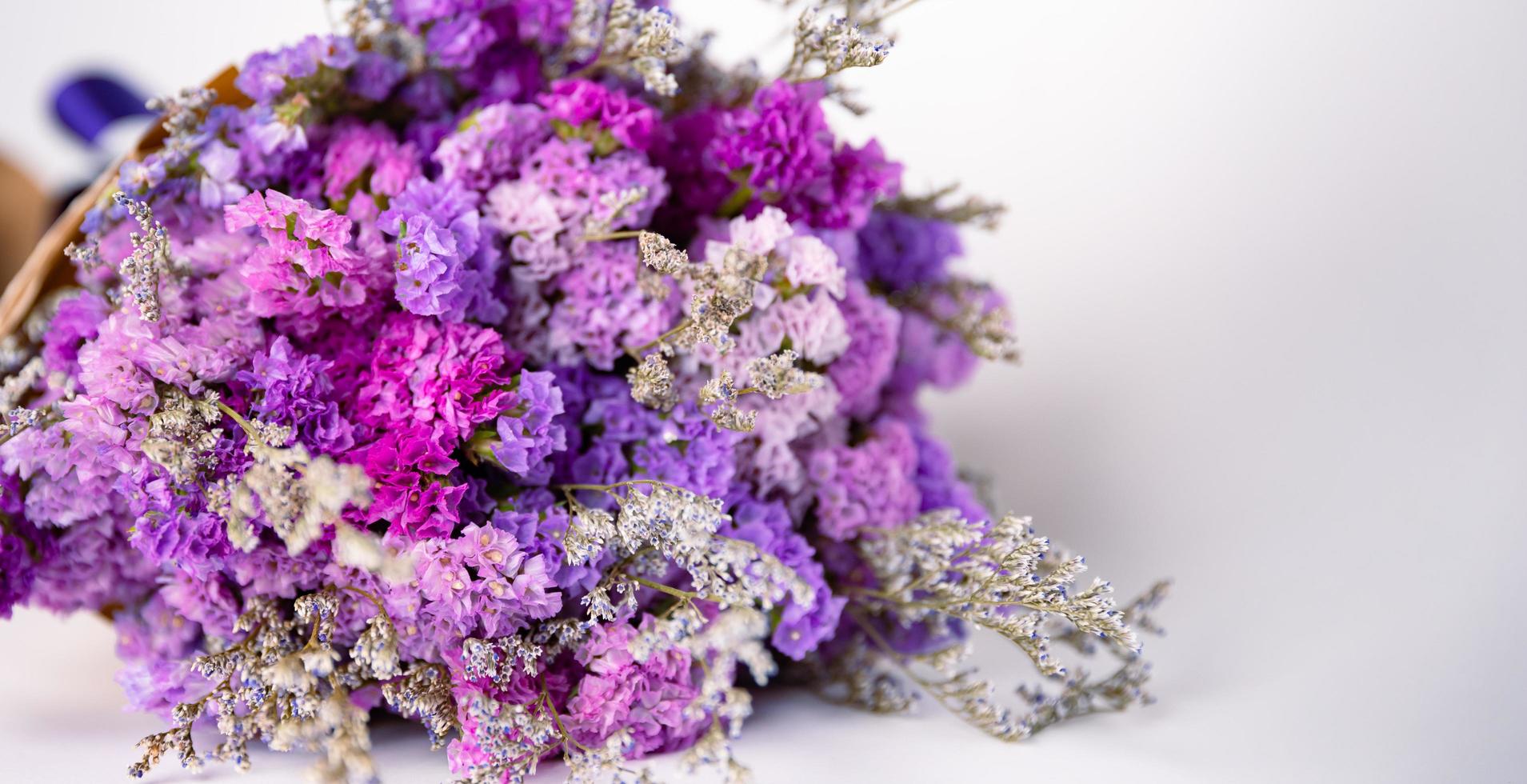 Close up shot of violet and colorful small flowers arranged in bouquet. photo
