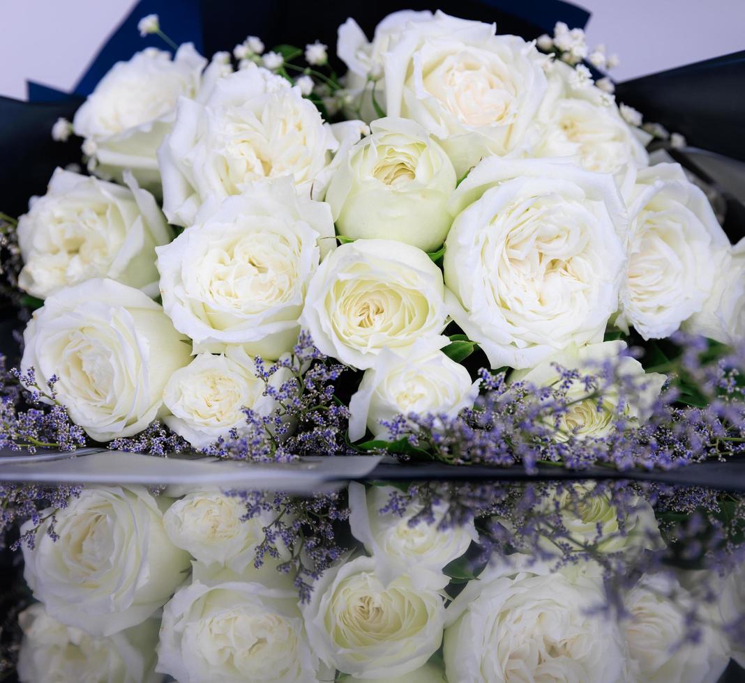 Beautiful big and a luxury bouquet of white roses arranged in a bunch with reflection on the floor photo