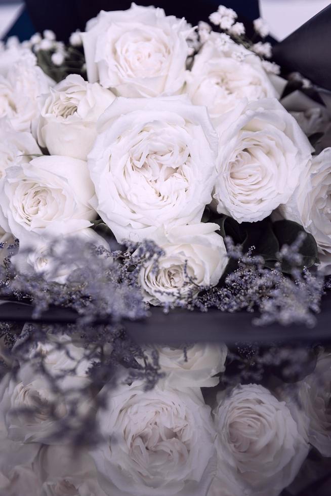 Beautiful big and a luxury bouquet of white roses arranged in a bunch with reflection on the floor photo