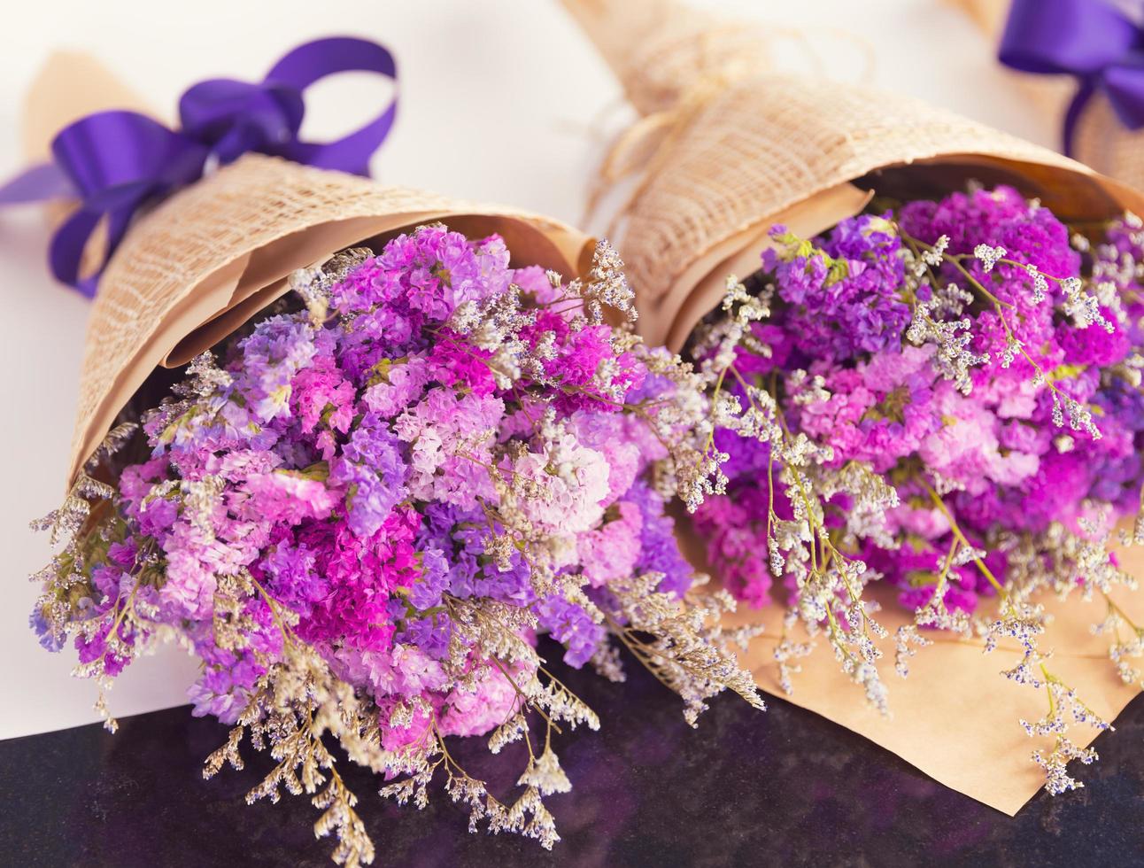 Close up shot of violet and colorful small flowers arranged in three bouquets. photo