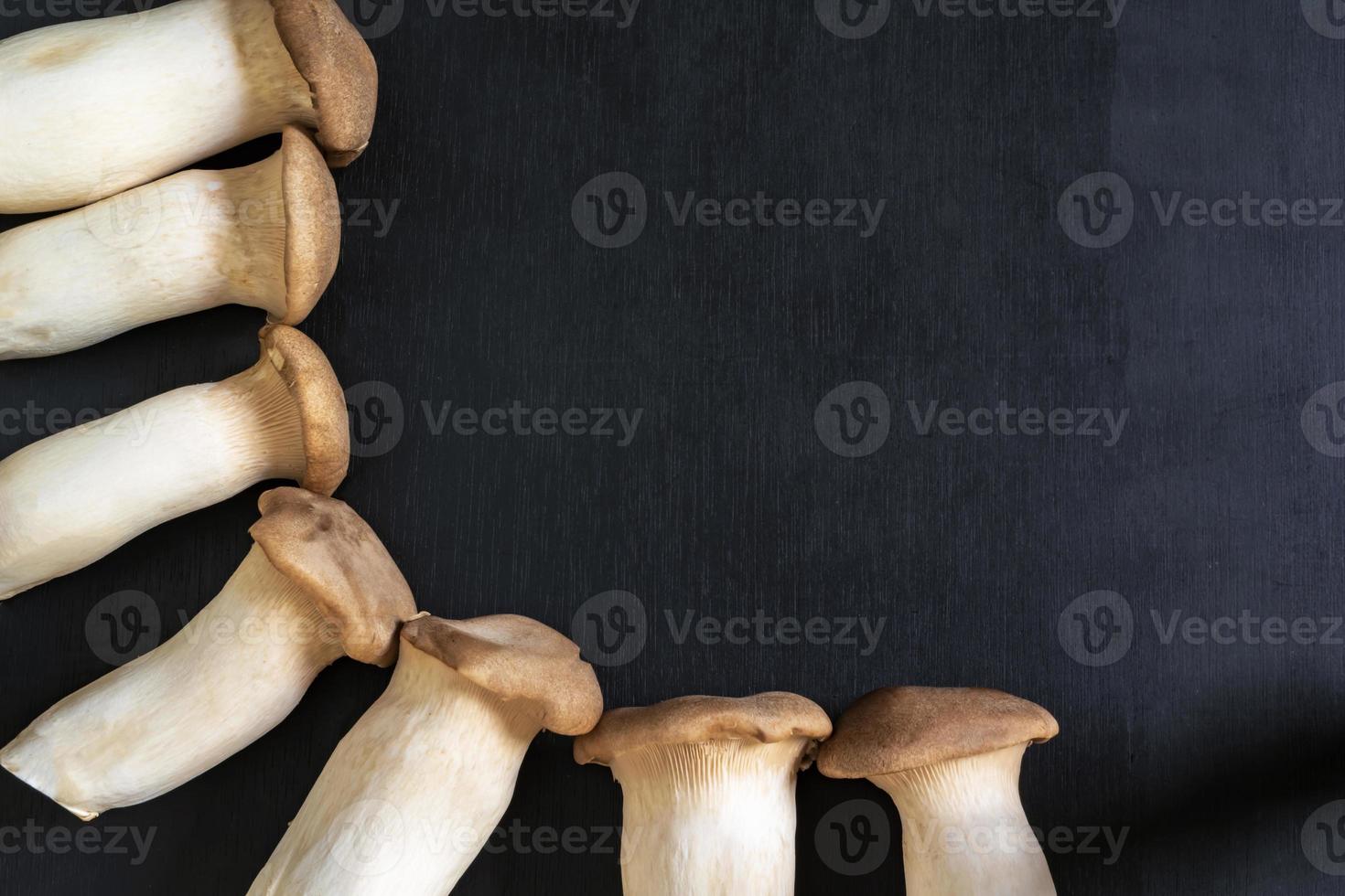 Healthy food king oyster mushroom on black wood background. photo