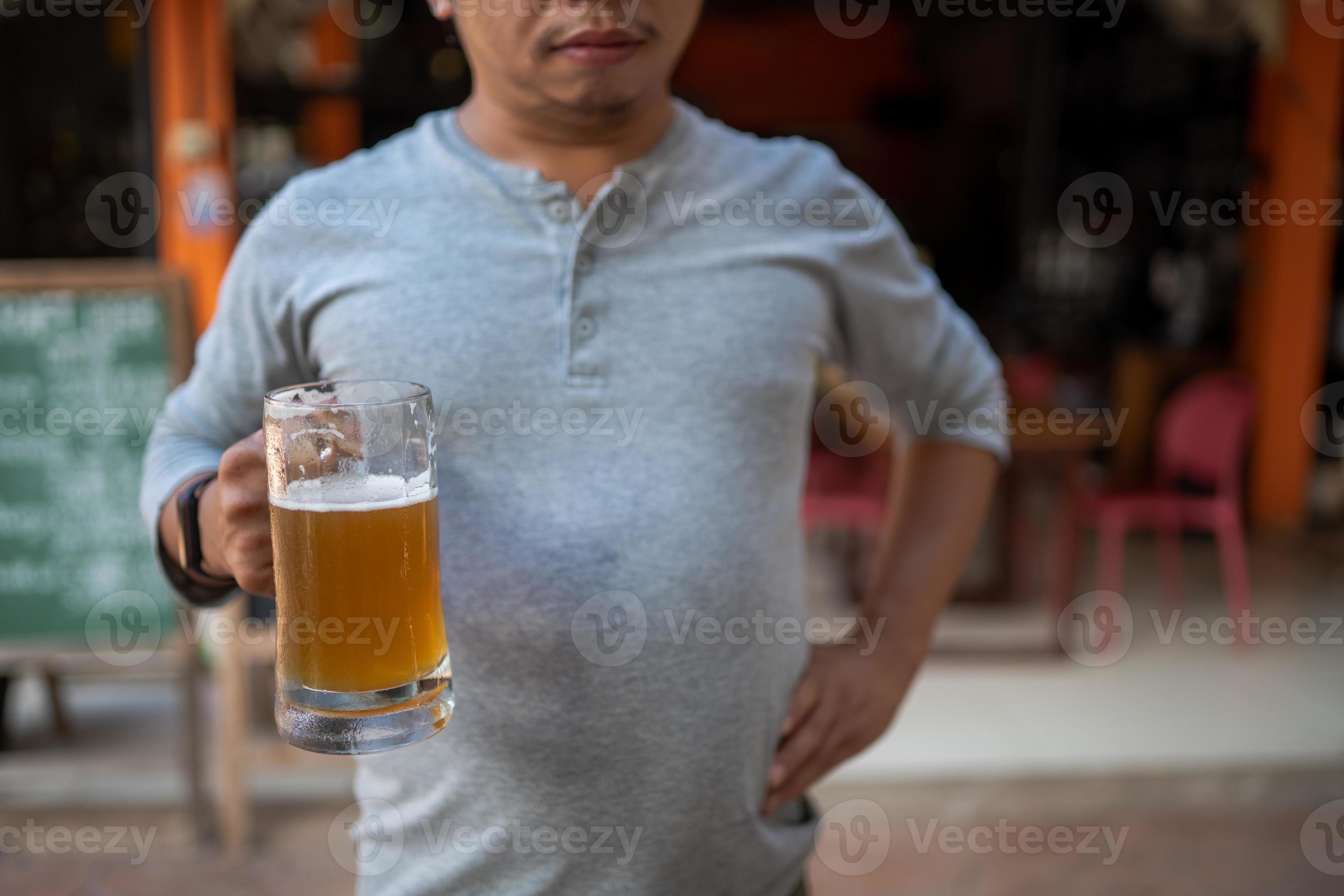 Young man holding a glass of beer and is it true that drinking beer
