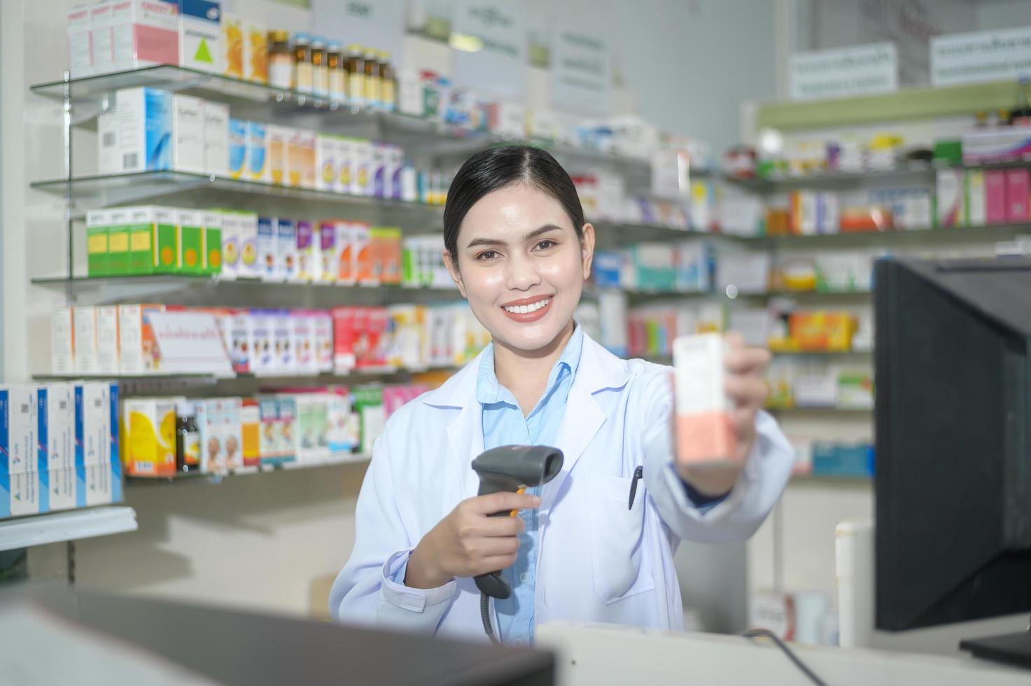 Farmacéutica femenina escaneando código de barras en una caja de medicamentos en una farmacia moderna. foto