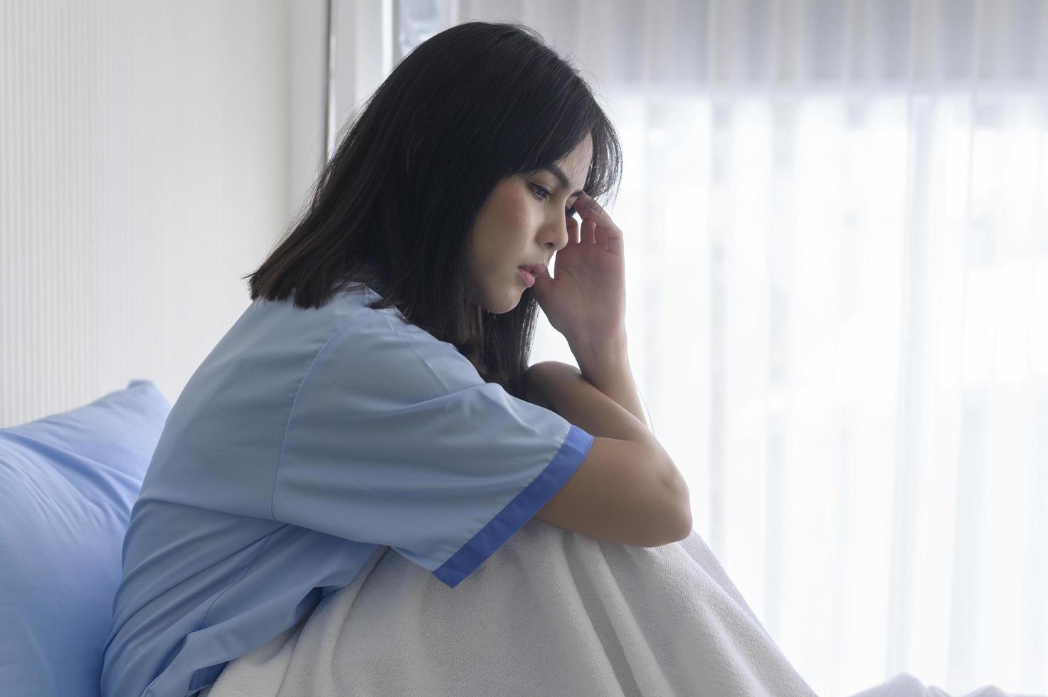 A despondent Asian woman patient. Following the doctor's declaration that the cancer was nearing the end of its course. photo