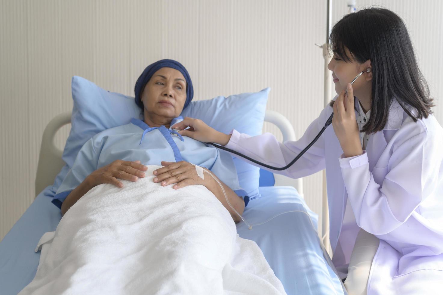 Cancer patient woman wearing head scarf after chemotherapy consulting and visiting doctor in hospital.. photo