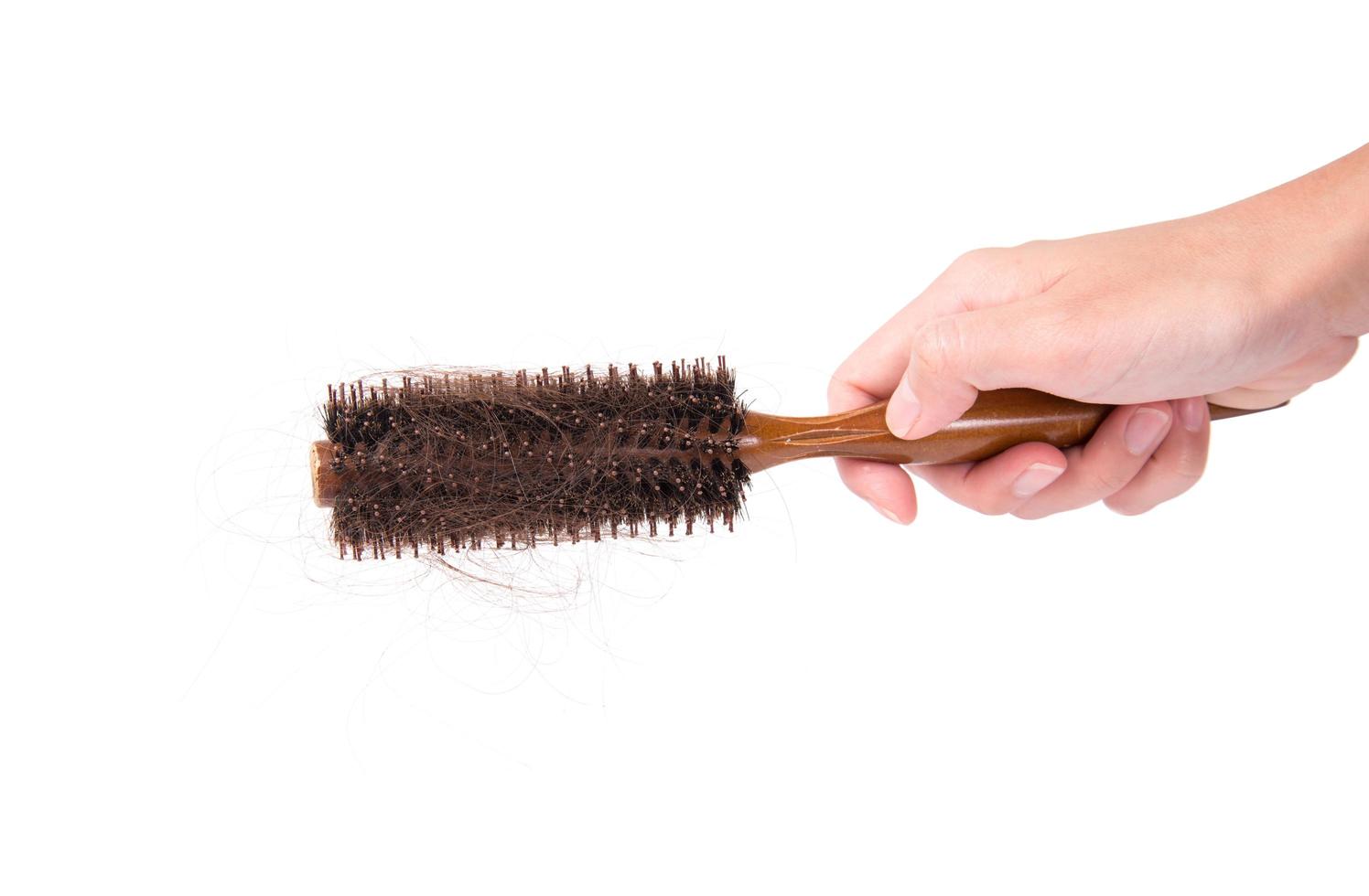 mujeres con problemas de cabello sosteniendo un peine de pérdida de cabello en la mano, isloated sobre fondo blanco foto