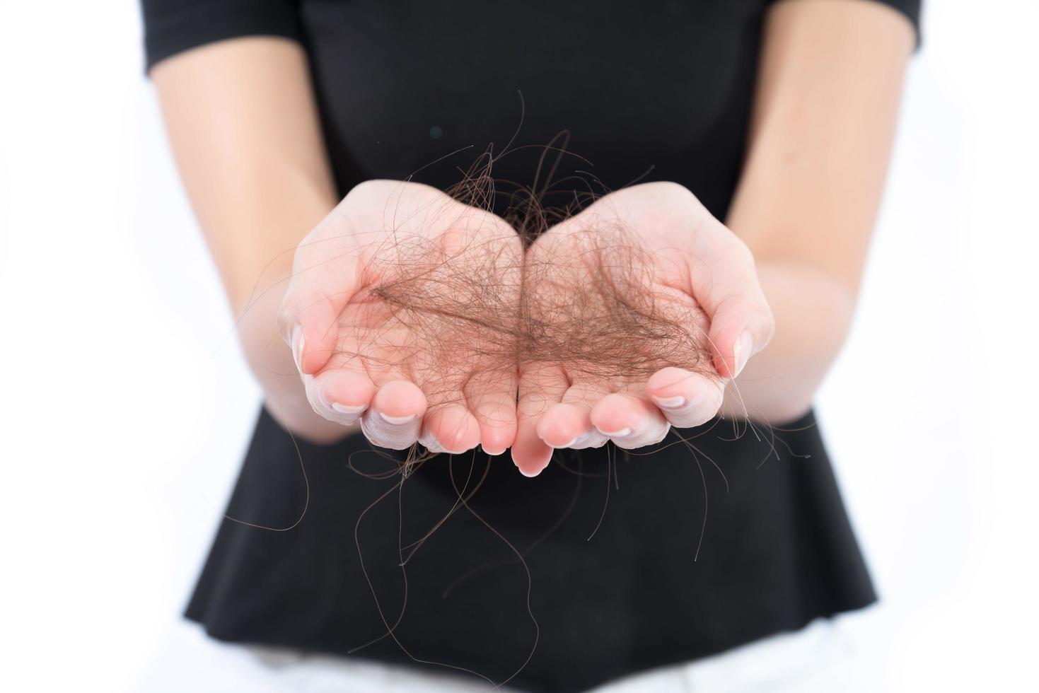 women with hair problem holding loss hair in hand, isloated on white background photo