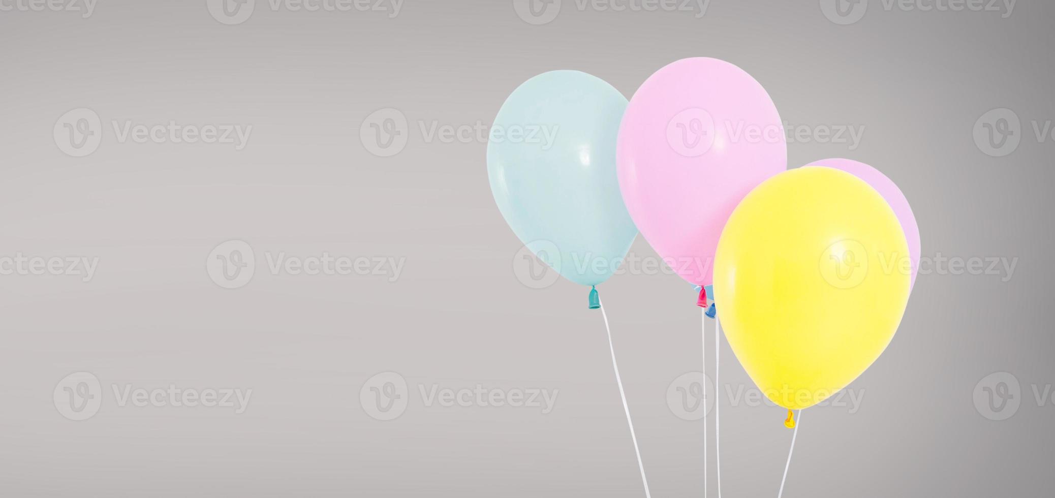 Globos de helio de colores aislados sobre fondo gris, concepto de cumpleaños foto