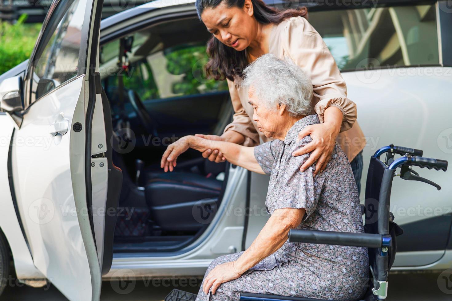 Caregiver help Asian elderly woman disability patient get in her car, medical concept. photo