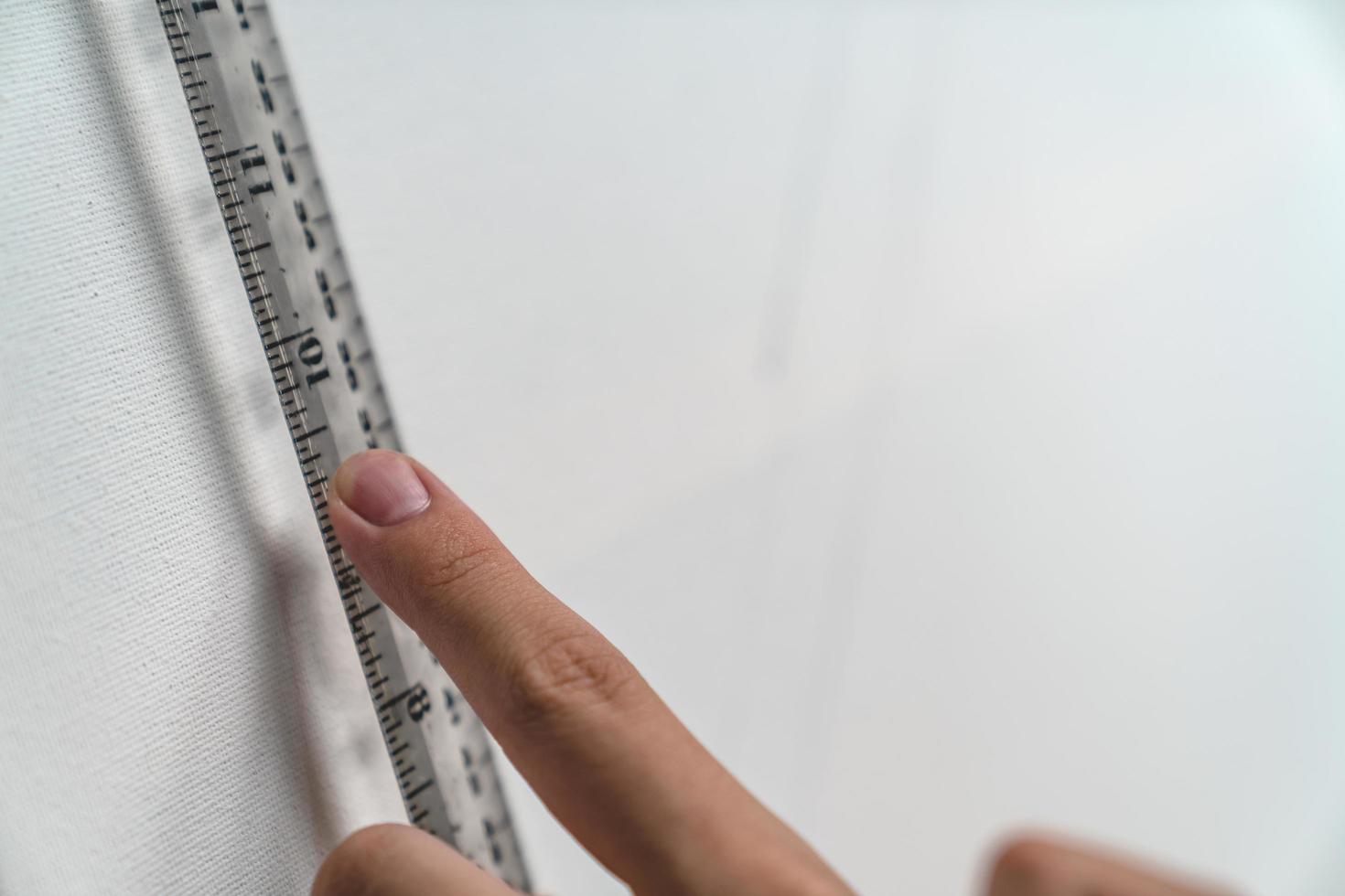 hand holding ruler with canvas background photo
