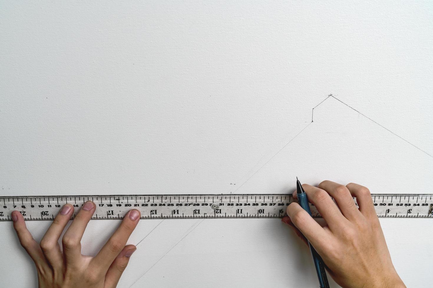 hand holding ruler and clutch-type pencil with canvas background photo