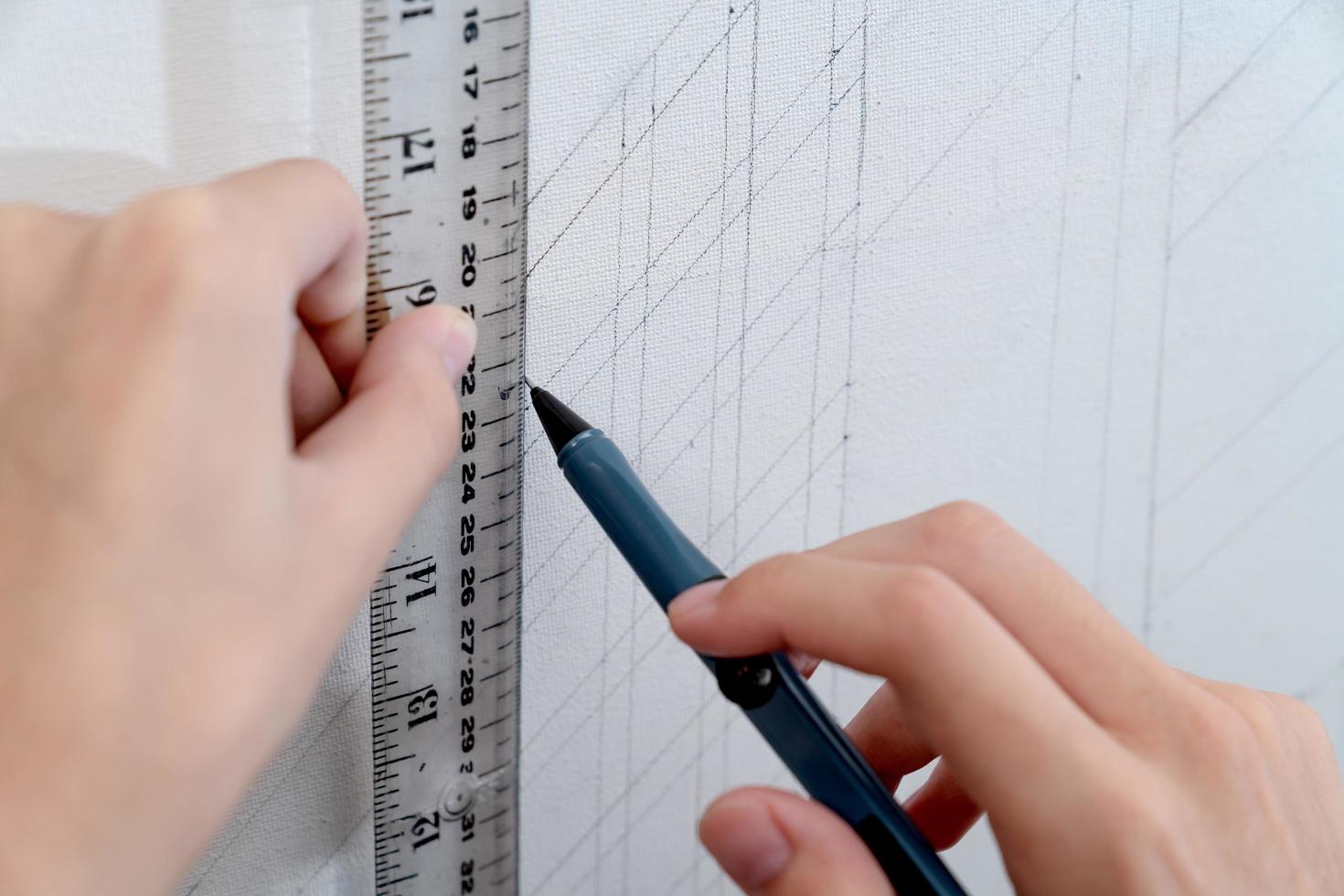 hand holding ruler and clutch-type pencil with canvas background photo