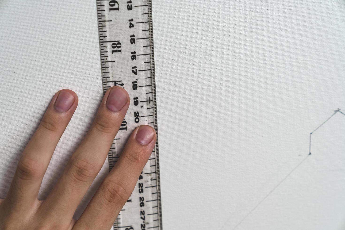 hand holding ruler with canvas background photo