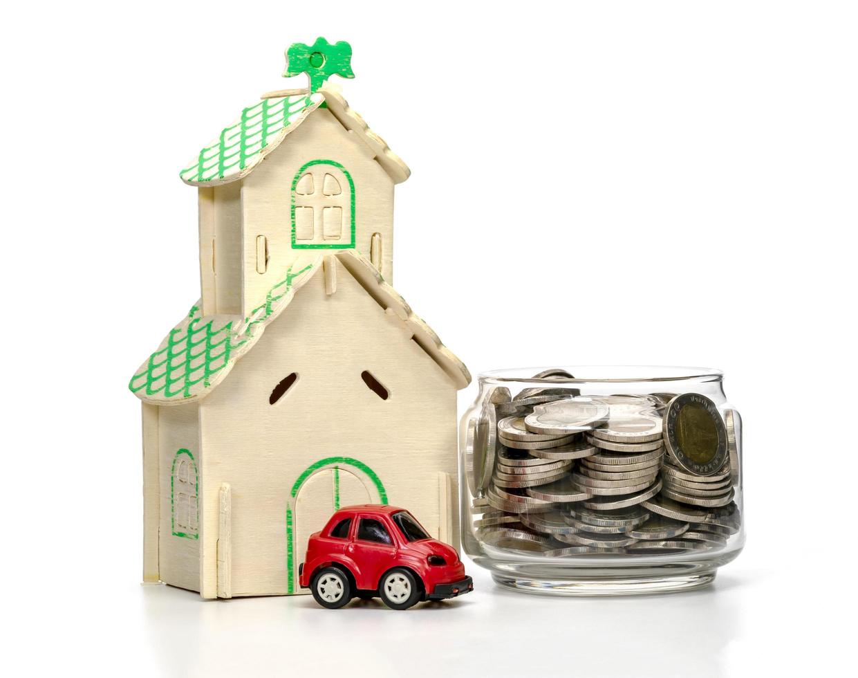 coins in glass bottle and car and house on white background,business saving and investment concept photo