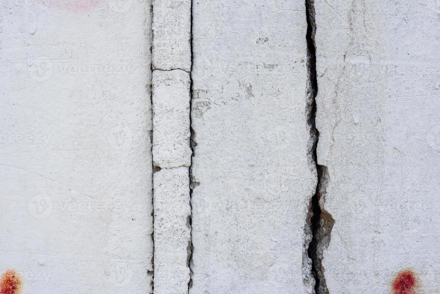 Texture of a concrete wall with cracks and scratches which can be used as a background photo