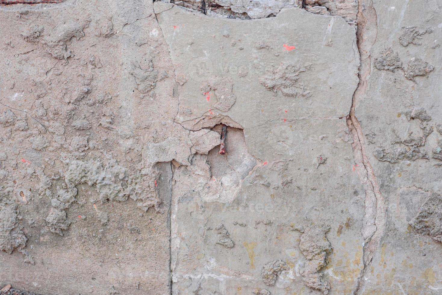 Texture of a concrete wall with cracks and scratches which can be used as a background photo