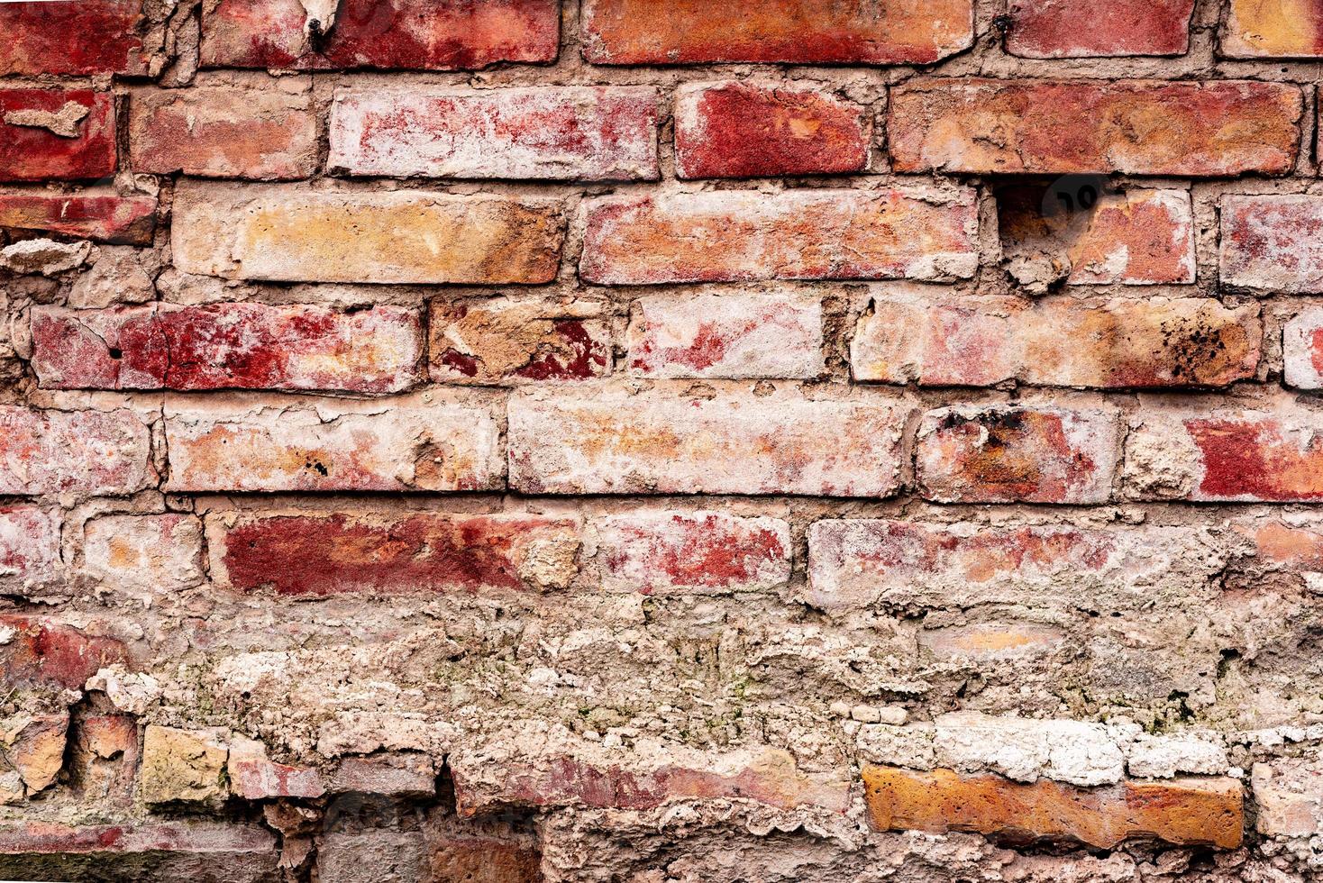 Texture of a brick wall with cracks and scratches which can be used as a background photo