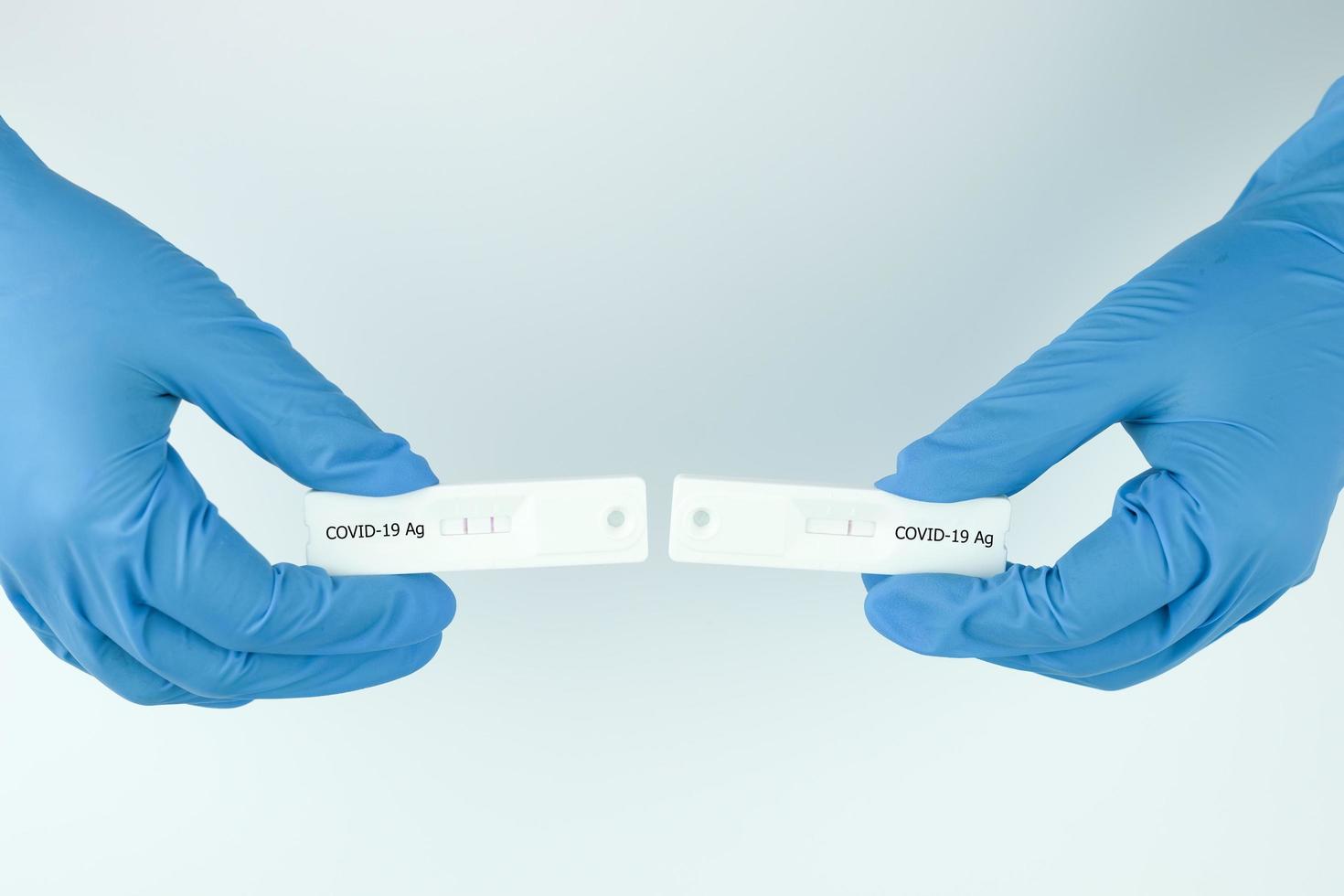 Medical personnel showing Covid-19 positive and negative test result with SARS CoV-2 Rapid antigen test kit ATK. Coronavirus infectious protective concept. photo