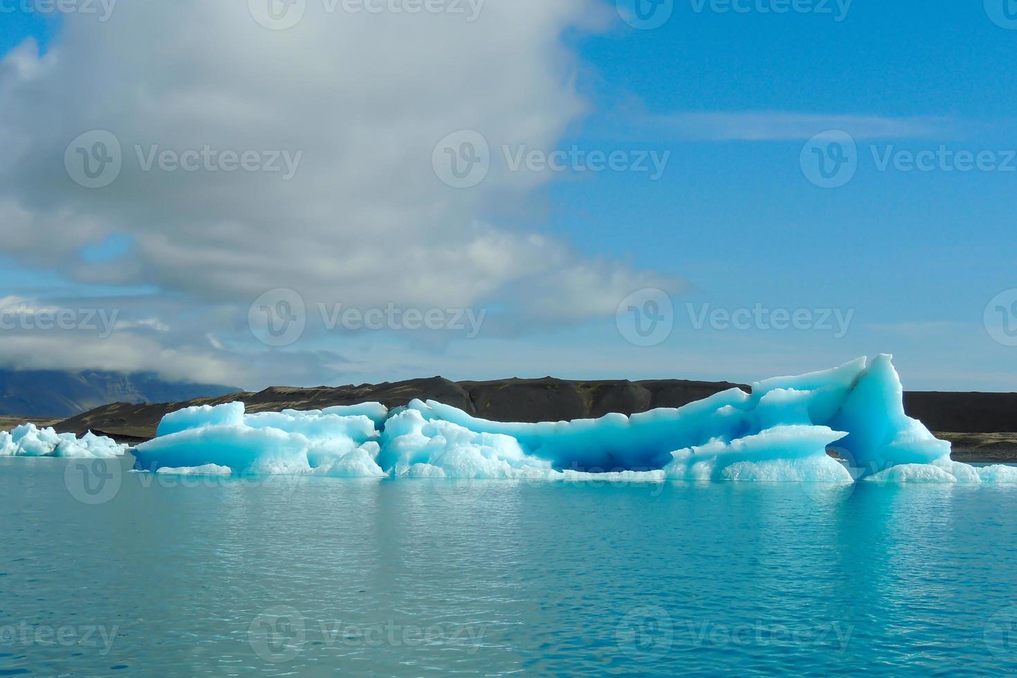 Bright clear blue iceberg floating in the Jokulsarlon lake blue cold water in Iceland 17 photo