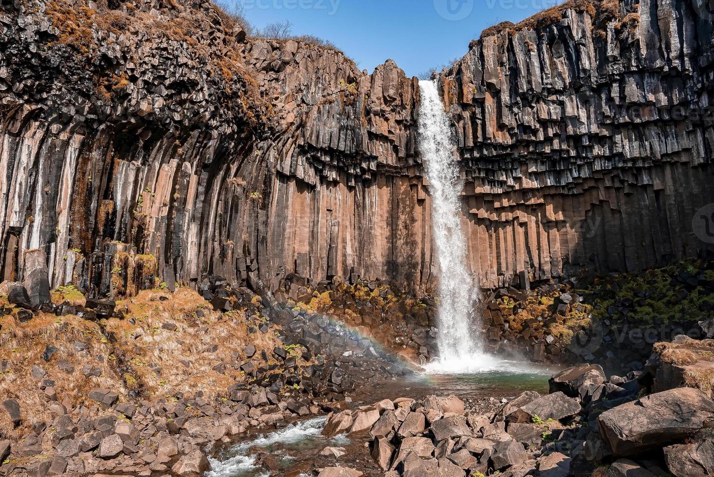 hermosas cascadas de cascada svartifoss y arroyo que fluye en el parque nacional foto