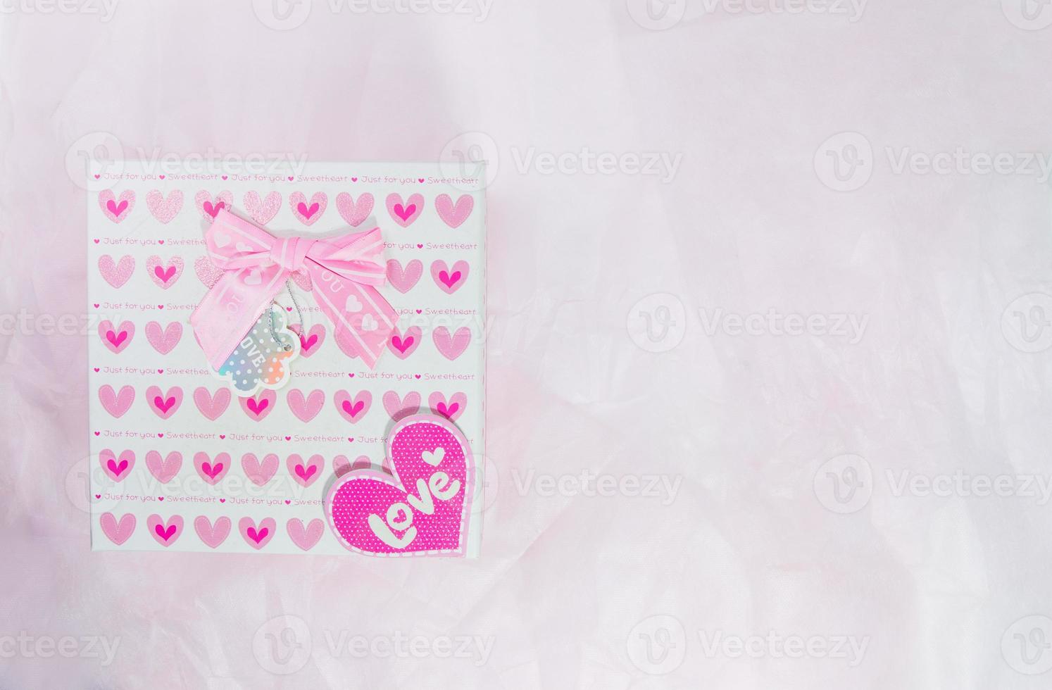 Heart pattern gift box on pink paper background, valentine festival photo