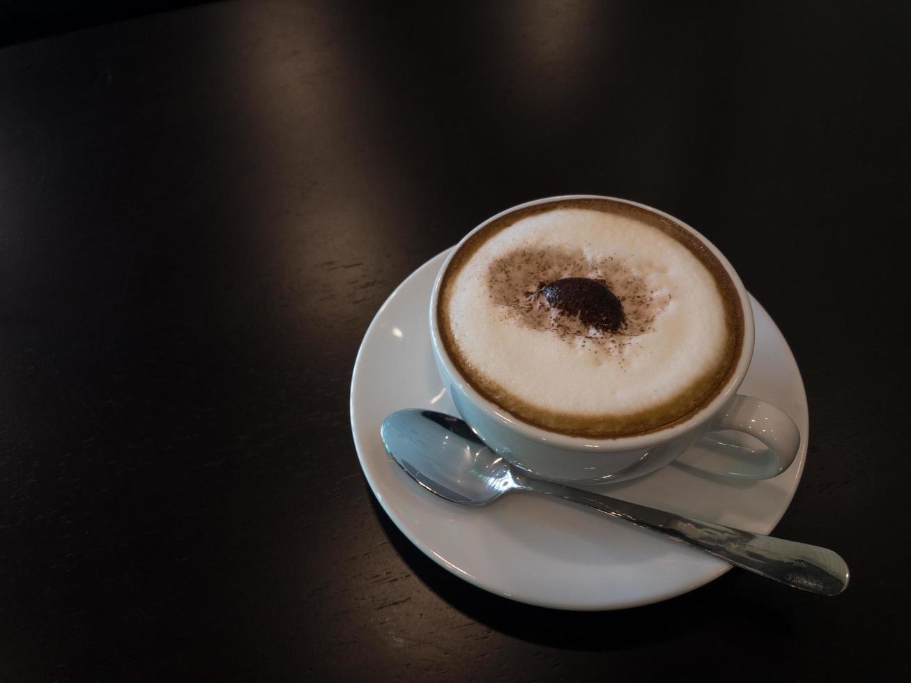 Frothy coffee and stainless steel spoons are placed on the table in the coffee shop.copy space photo