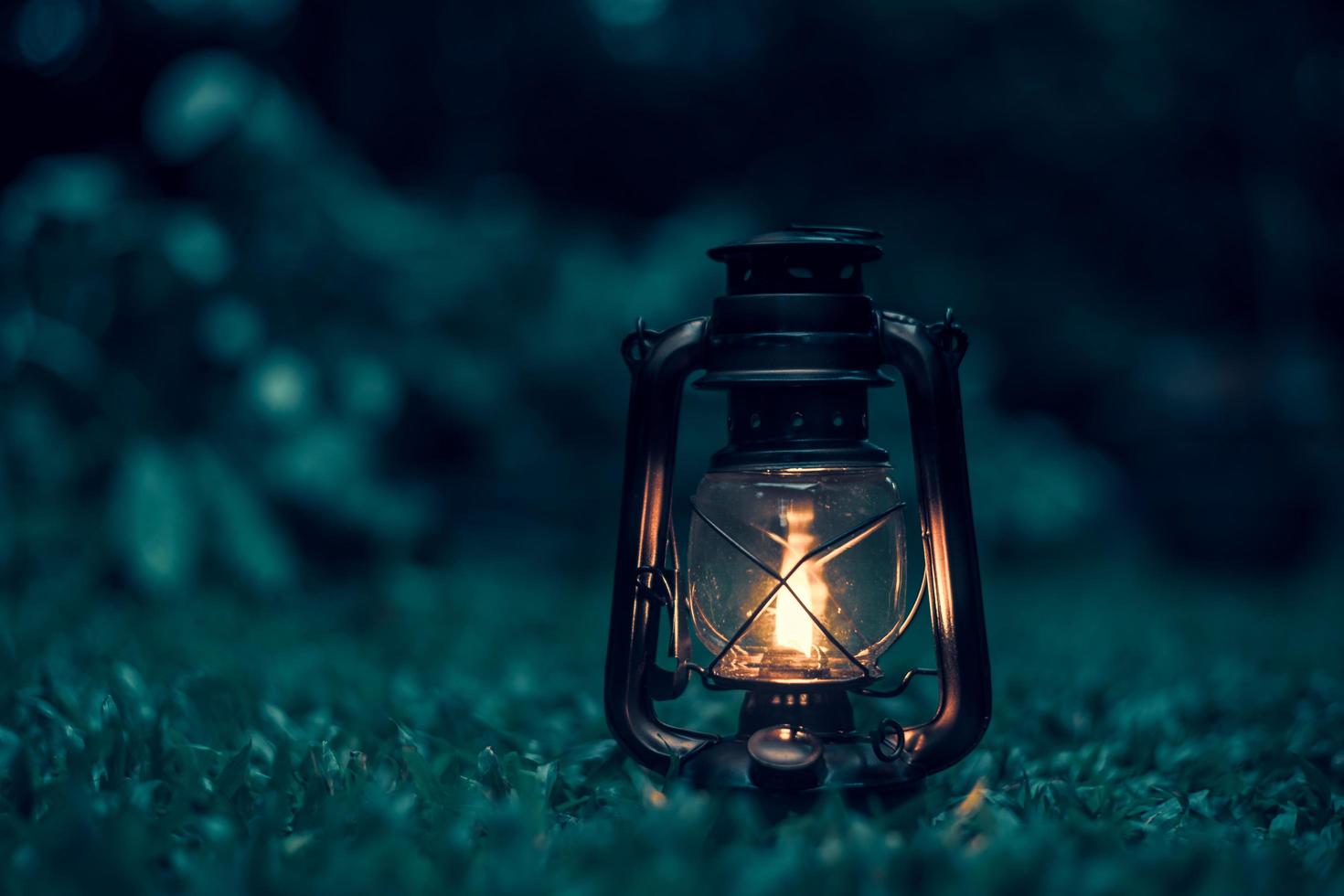 antique kerosene lamp on the grass in the forest at night.soft focus. photo