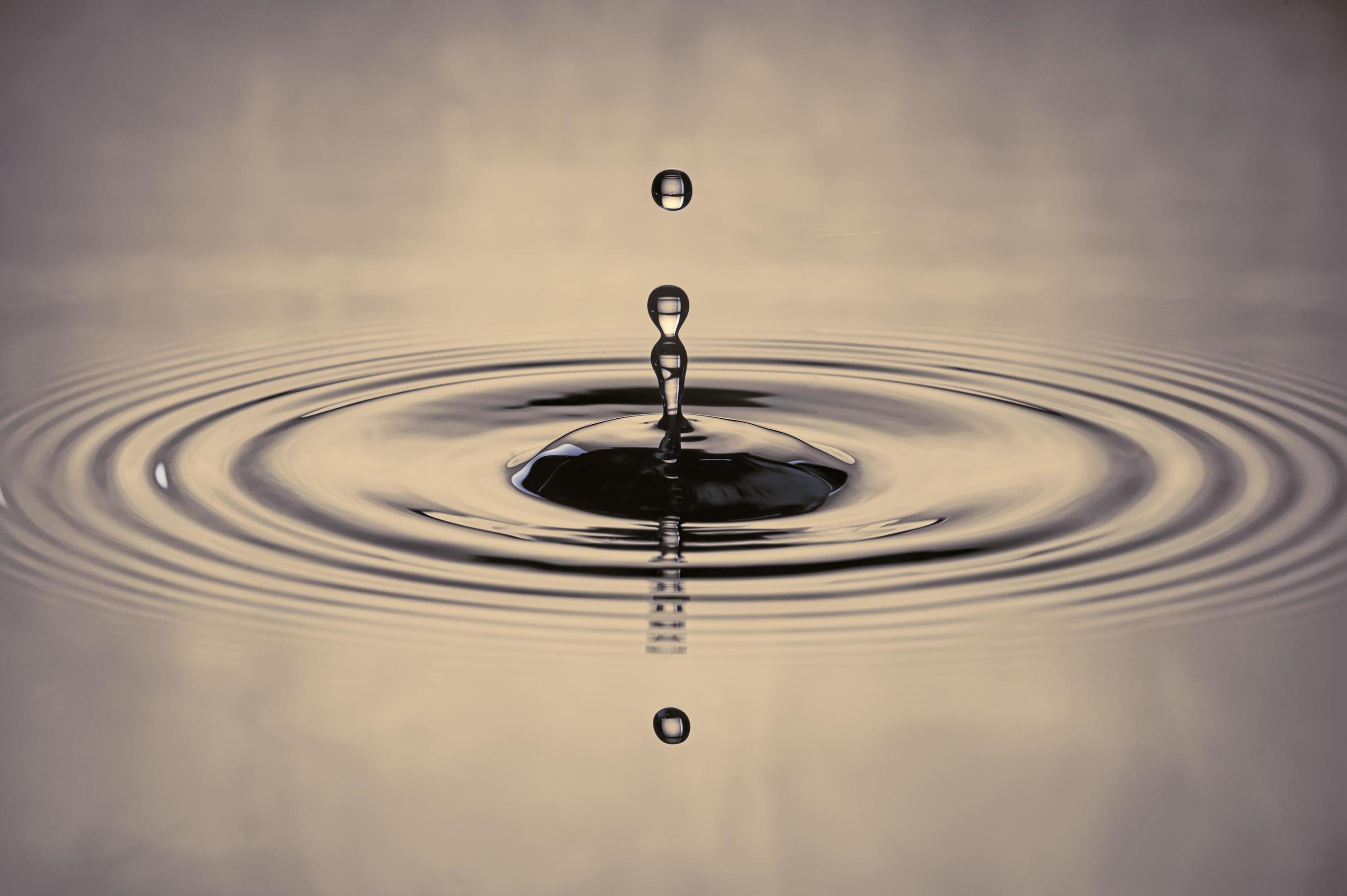 water drop splash in a graycolored shot of water that is dripping and