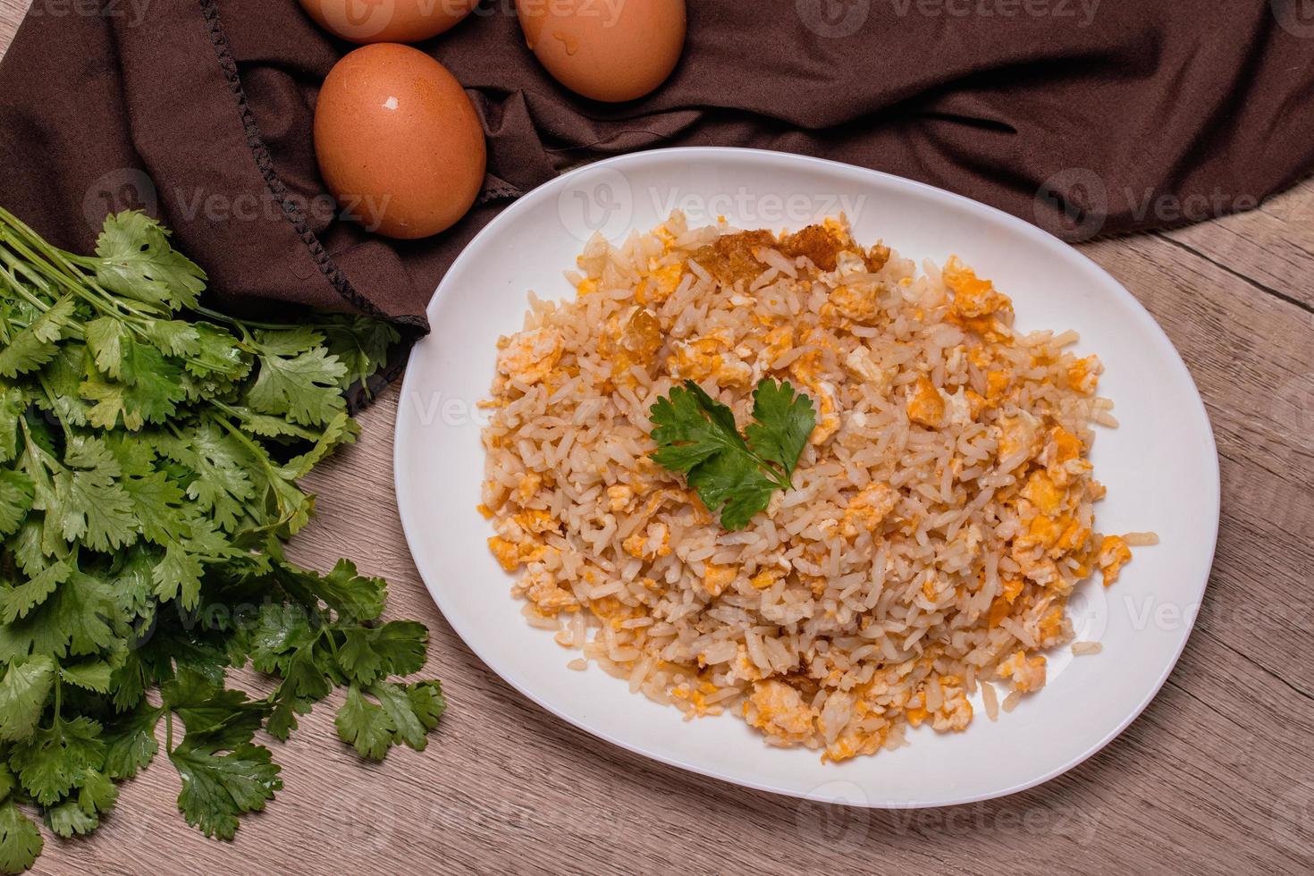 Thai food egg fried rice in white plate on wooden floor photo