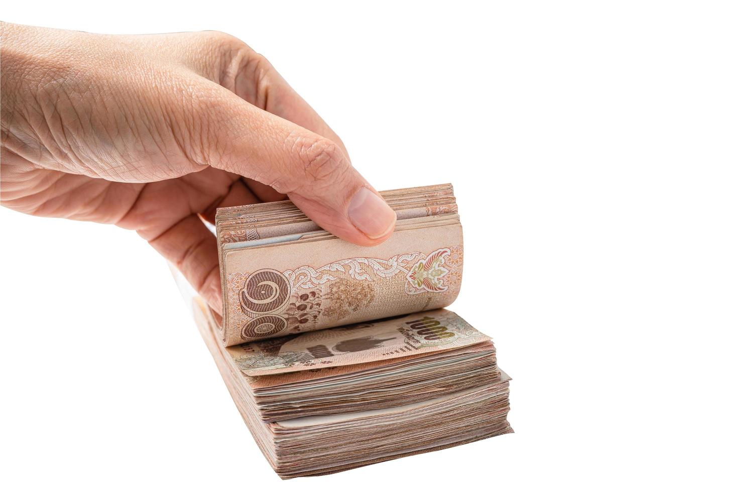 Asian hand with stack of Thai baht banknotes on white background with clipping path, business saving finance investment concept. photo