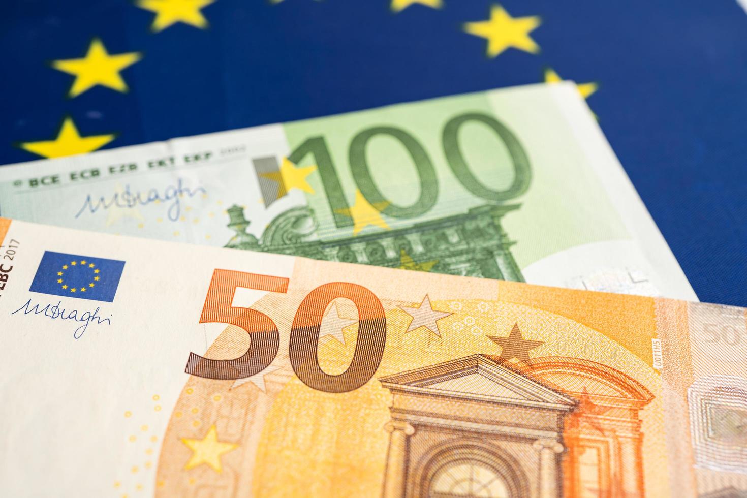 Euro banknotes on EU flag, finance and accounting, banking concept. photo