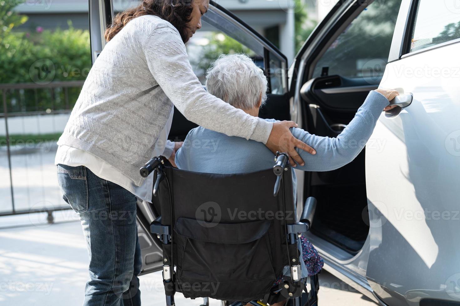 Asian senior or elderly old lady woman patient sitting on wheelchair prepare get to her car, healthy strong medical concept. photo