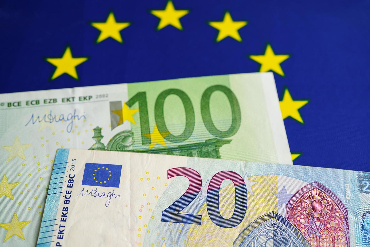 Euro banknotes money on EU flag, economy trade in europe concept. photo