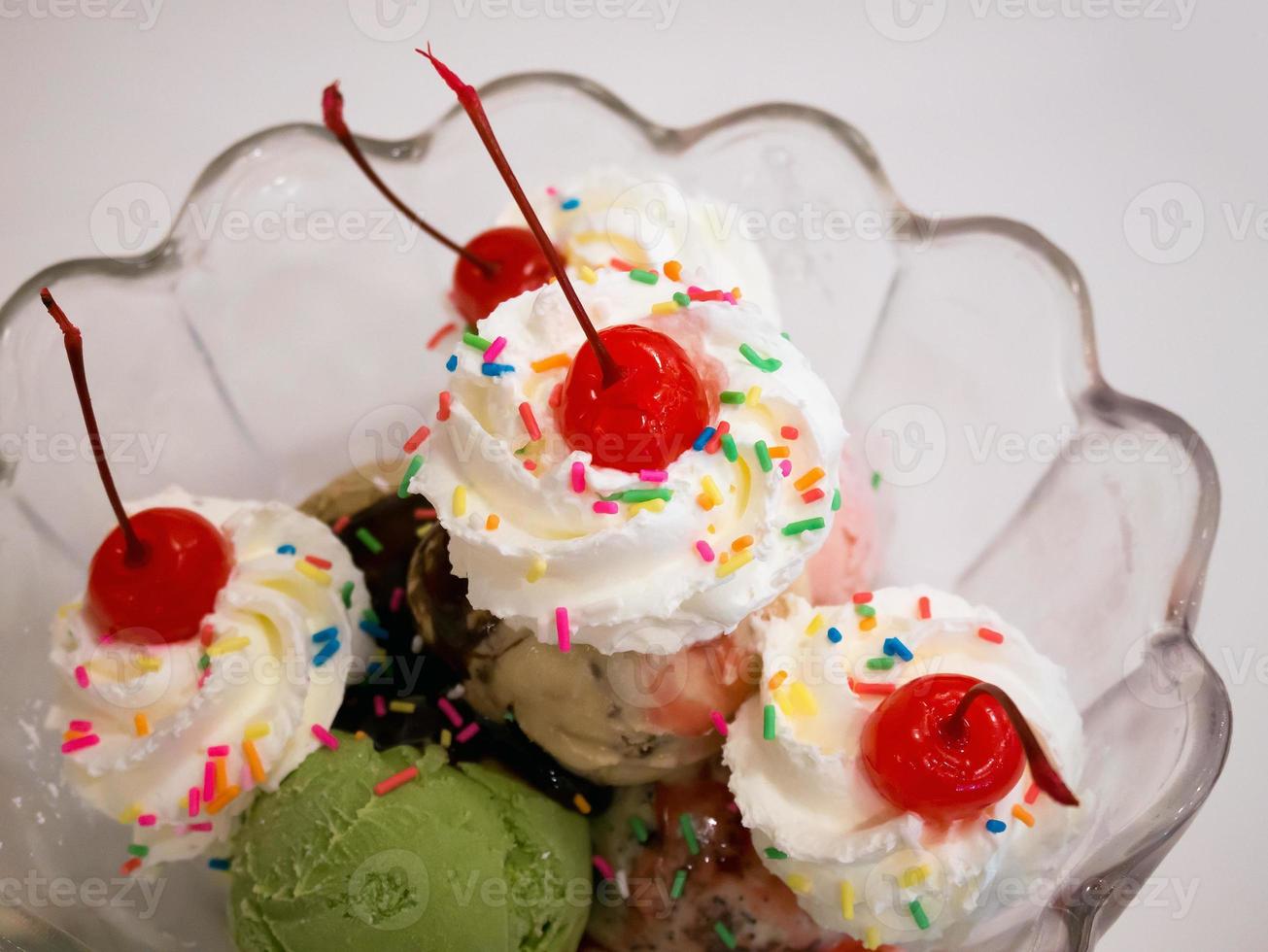 Ice cream scoops with cherry and whipped cream photo