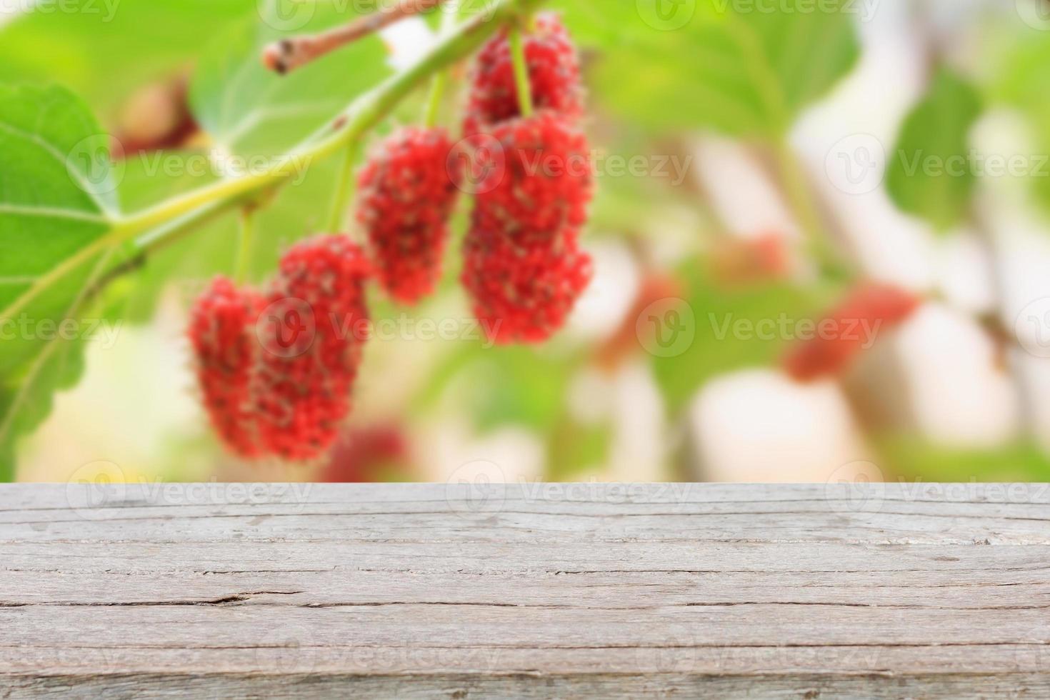 wood table with red mulberries background photo