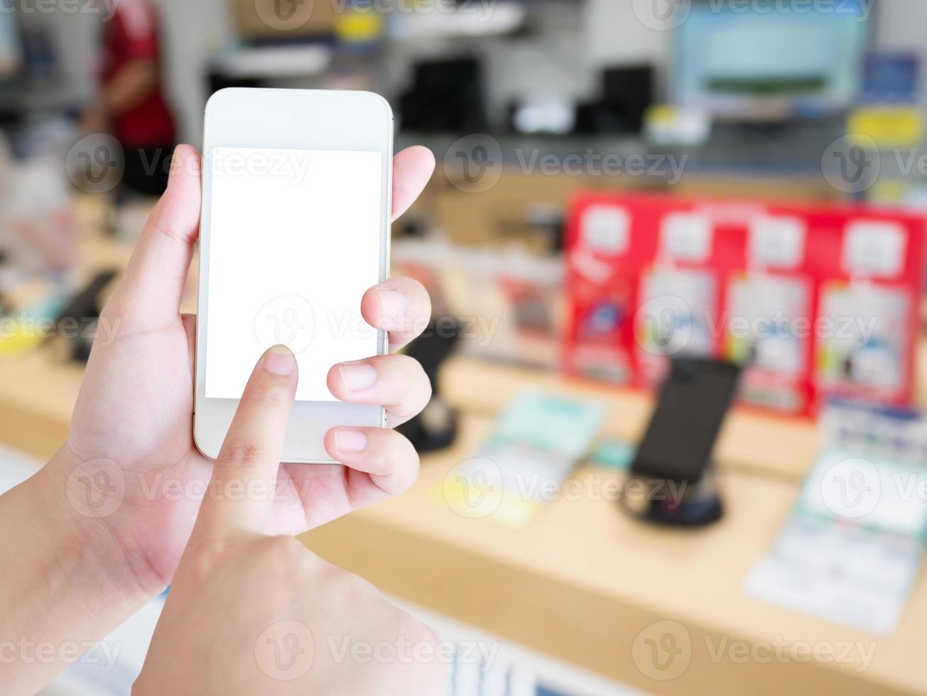 mano femenina sostenga el teléfono inteligente móvil en la tienda de teléfonos móviles foto