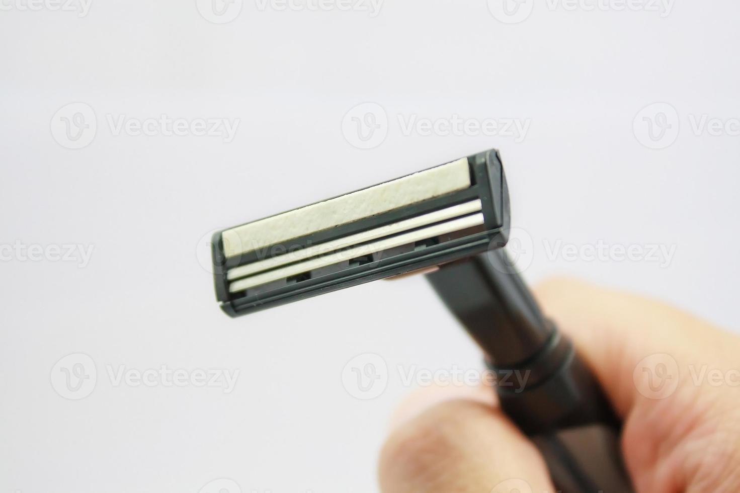 Hand with shaving razor isolated on a white background photo
