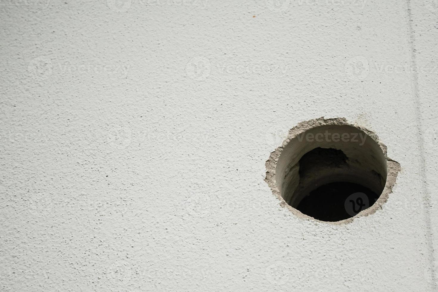 hole in white concrete wall photo