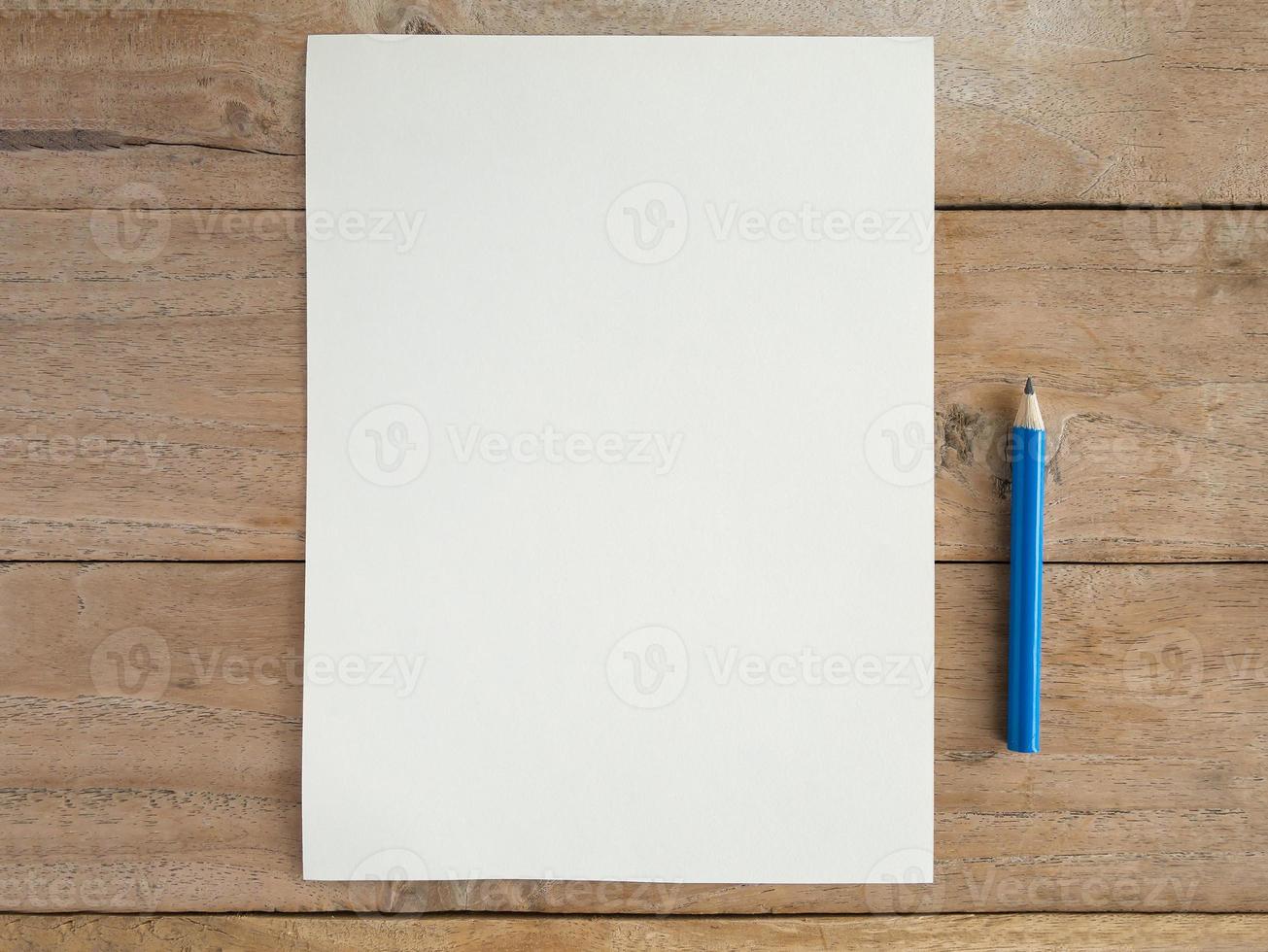 Blank paper with pencil on wood table photo